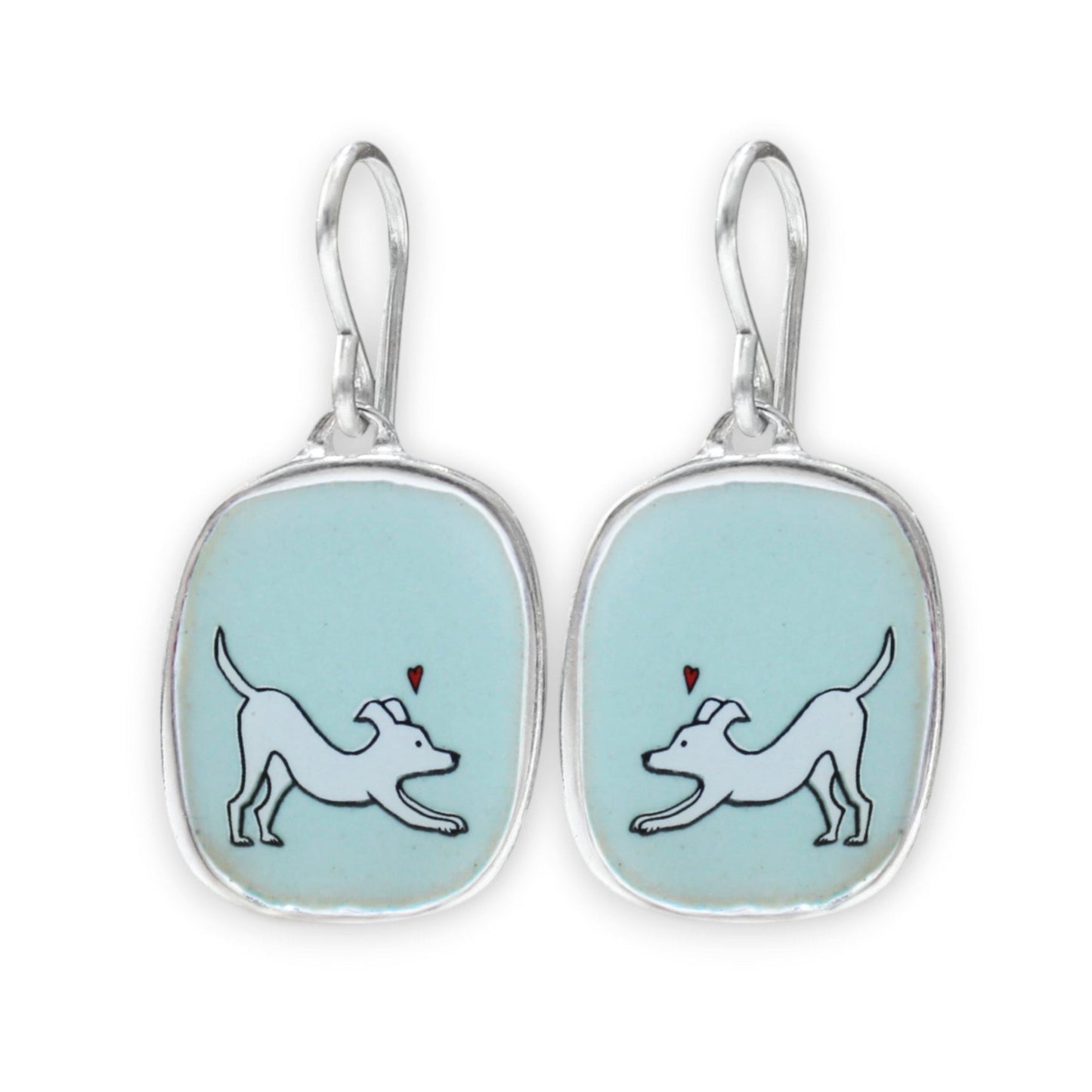 A pair of silver drop earrings with rounded rectangular bezel settings containing a light blue enamel background. Each earring features a white line-art illustration of a dog with a small red heart above it.