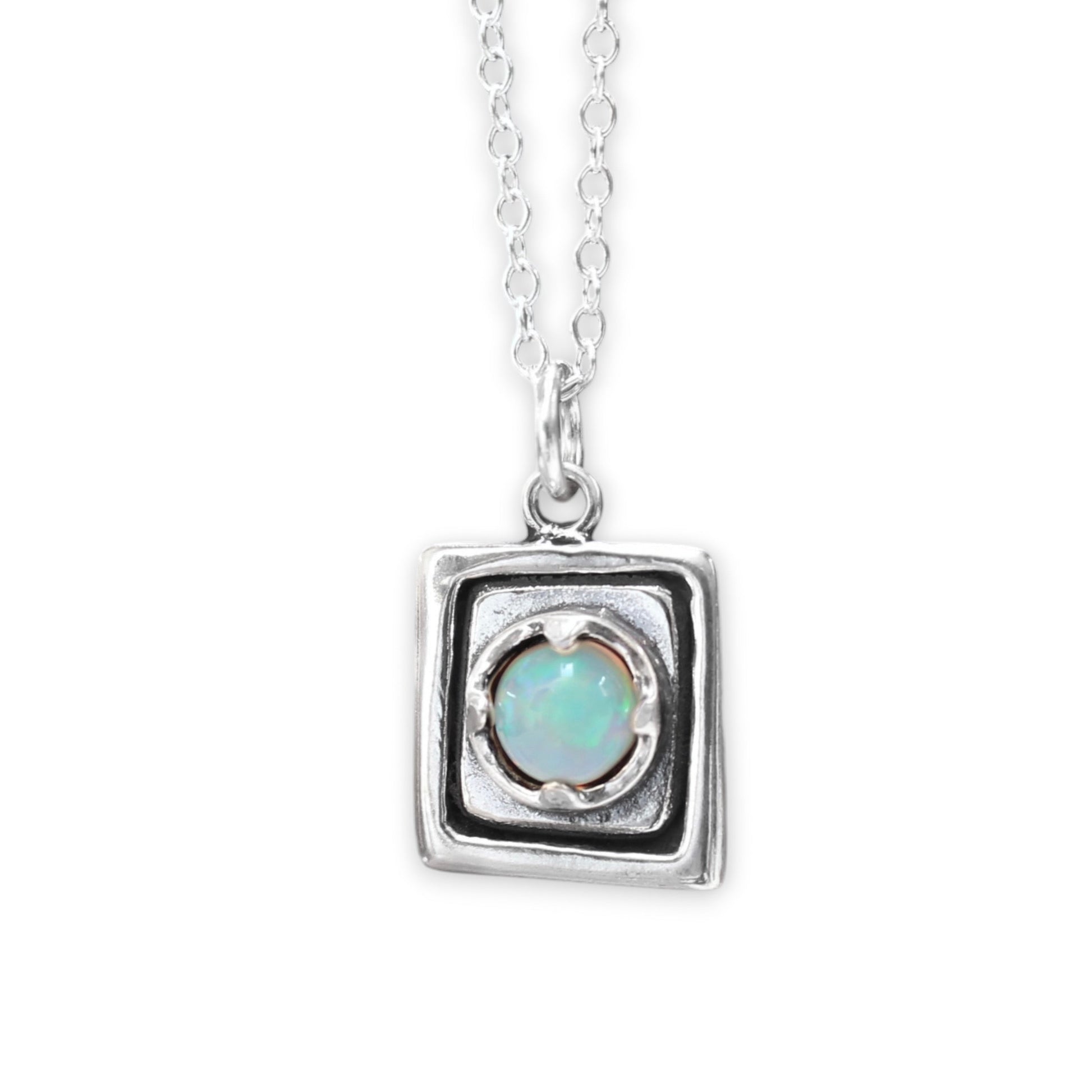 Silver pendant with a central gemstone on a white background