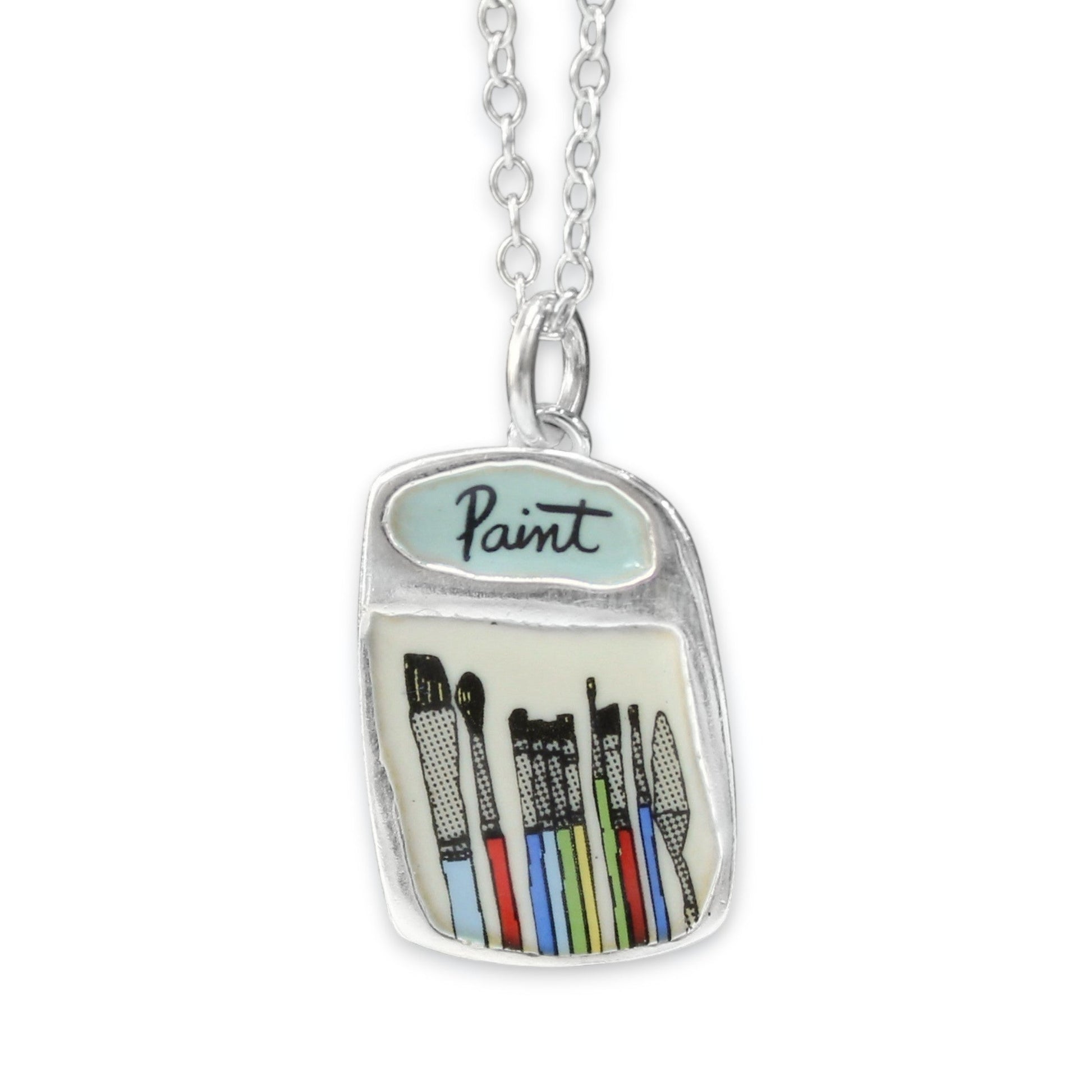 A silver pendant necklace shaped like a paint jar, featuring a light blue enamel top with the word 'Paint' and colorful illustrated paintbrushes inside, shown on a white background.